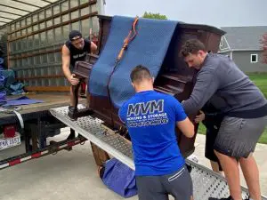MVM Moving & Storage employees moving a piano