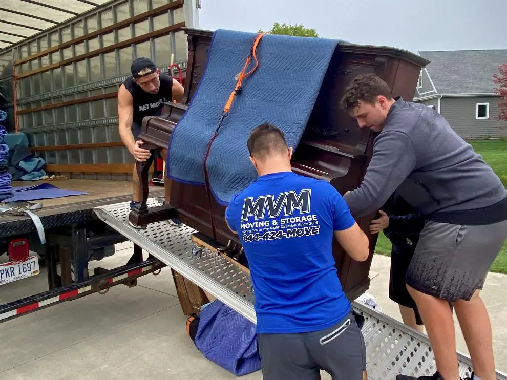 MVM Moving & Storage employees moving a piano