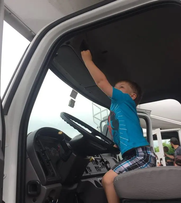 Child getting ready to move honking the horn in the MVM moving truck