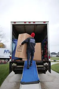 MVM Moving & Storage loading boxes into a moving truck from a checklist