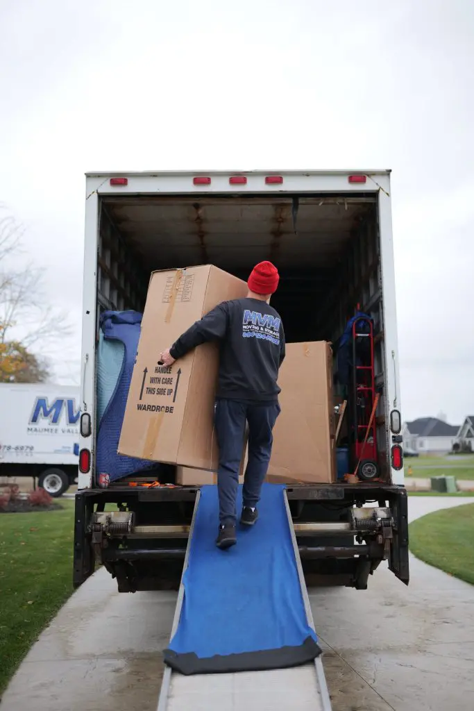 MVM Moving & Storage loading boxes into a moving truck from a checklist